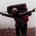 Glad bärare på väg mot Kilimanjaro